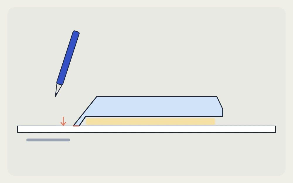 Side view of a ruler with its beveled edge down and raised off the paper, beside a pen tip