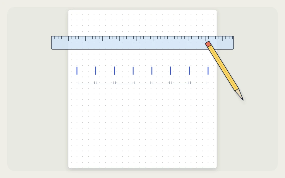 Ruler lying across a dot-grid page with small tick marks dividing the width into equal columns